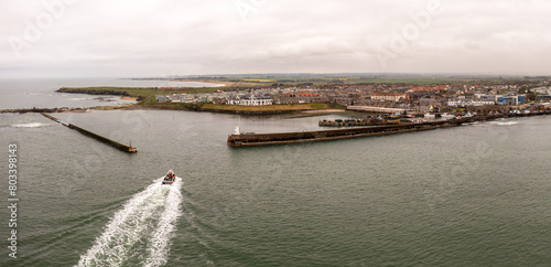 Aerial landscape view of a tourist boat trip returning to Seahouses harbour from the Farne Islands photo