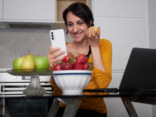 Woman make a pictures of strawberries at home kitchen

