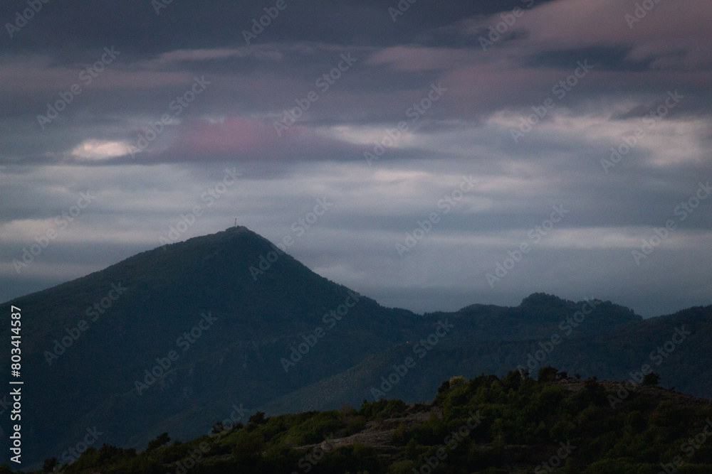 Beautiful view of the mountains and the dark cloudy sky after sunset.