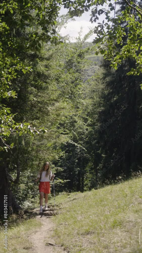 Summer Trek: Blonde Adventurer with Poles on Forest Trail