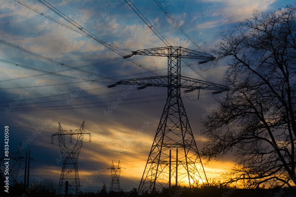 Power grid transmission tower network at sunset