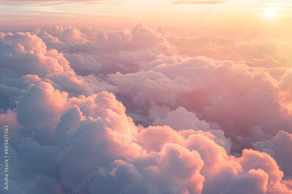 A mesmerizing shot of fluffy white clouds tinged with pink and orange as the sun begins to set, creating a dreamlike atmosphere in the sky.