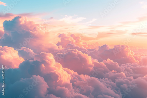 A mesmerizing shot of fluffy white clouds tinged with pink and orange as the sun begins to set, creating a dreamlike atmosphere in the sky. photo