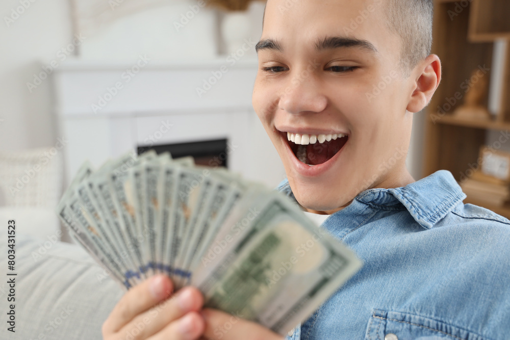 Happy young man with dollar banknotes at home, closeup Happy young man with dollar banknotes at home, closeup