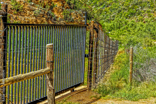 Steel security gate and electric fencing protecting an orchard  in the Little Karoo near Oudtshoorn, Western Cape, South Africa photo