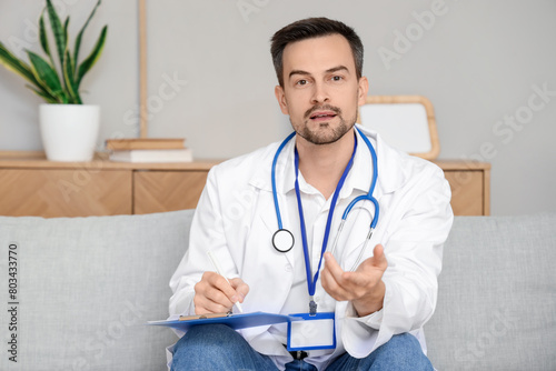 Handsome doctor with clipbo...