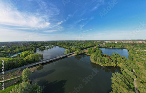 Aerial view of serene lake, trees, and bridge in beautiful natural landscape Hanover Ricklinger Teiche Germany