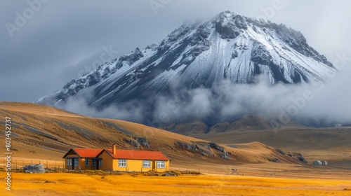 A small yellow house sitting in a field next to a mountain  AI