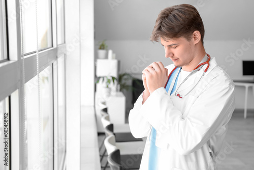 Male medical intern praying...