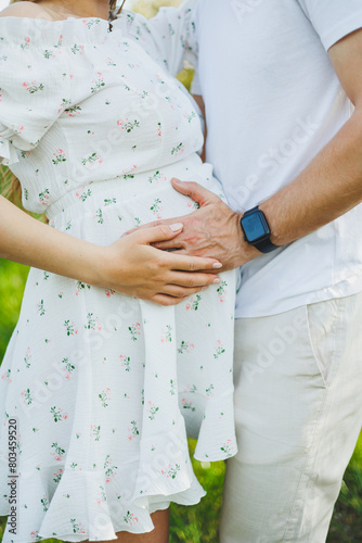 Hands of man and woman on pregnant belly. A pregnant woman hugs her husband