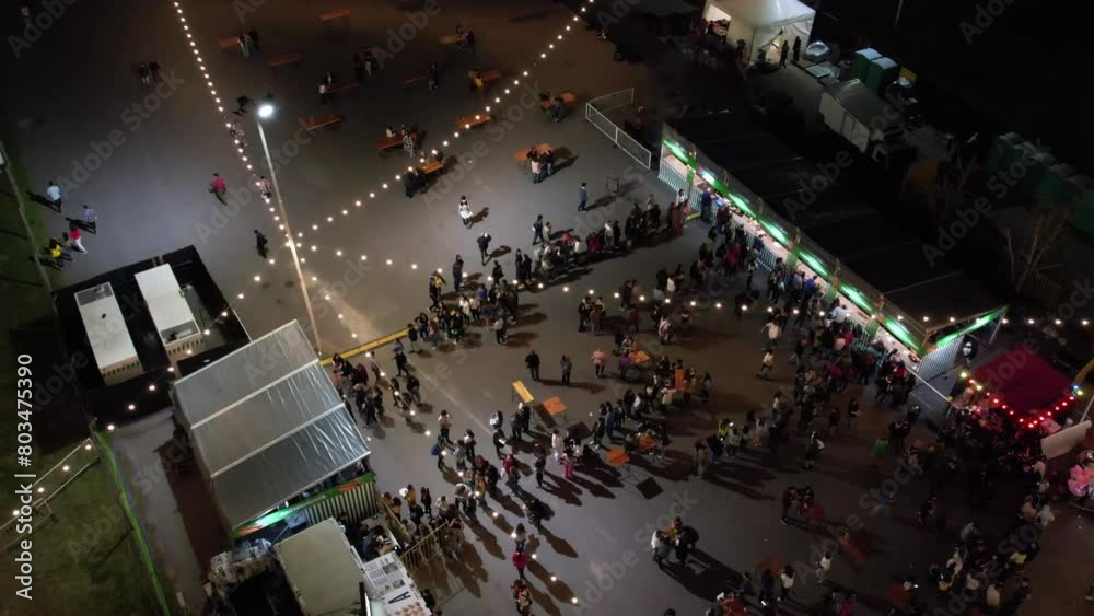 Multitud de gente haciendo fila en un evento nocturno.