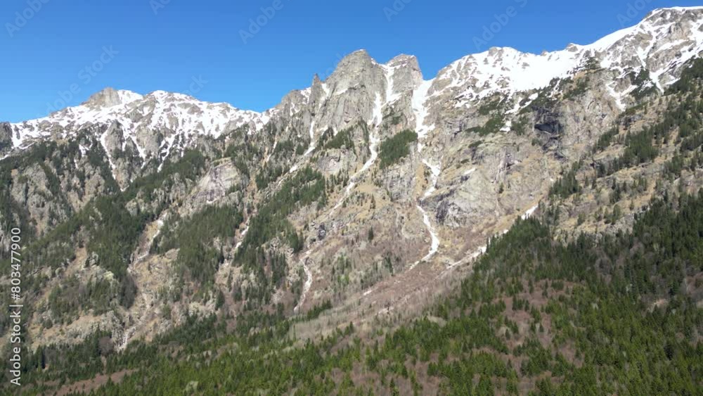 Aerial drone shot of the snowy peaks of Rila Moutain in Bulgaria. East european alps shot of mountain peaks, cliffs and rock formations. Snow melting on the face of alpine mountain seen from a drone.
Aerial drone shot of the snowy peaks of Rila Moutain in Bulgaria. East european alps shot of mountain peaks, cliffs and rock formations. Snow melting on the face of alpine mountain seen from a drone.