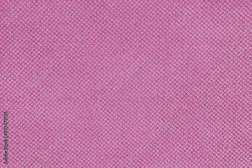 Plain pink velor upholstery fabric, jacquard with fine diamond texture background. Close up, macro cloth textile surface. Wallpaper, backdrop with copy space