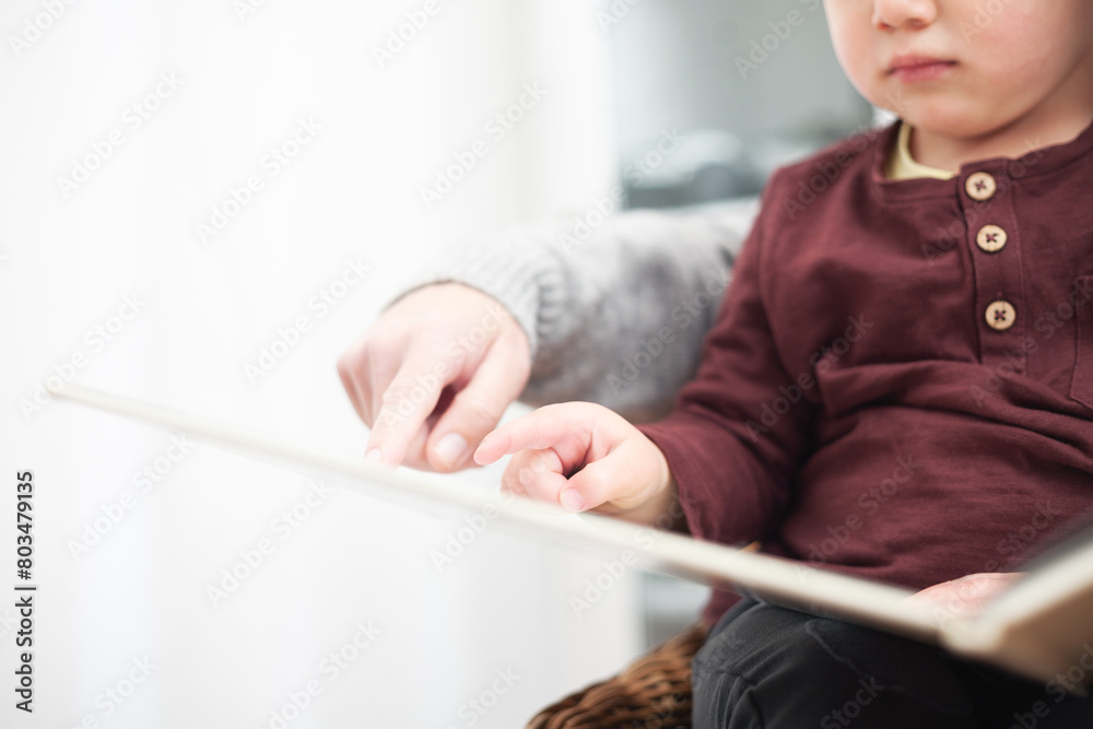 A child is sitting in a chair with a book in front of him A child is sitting in a chair with a book in front of him