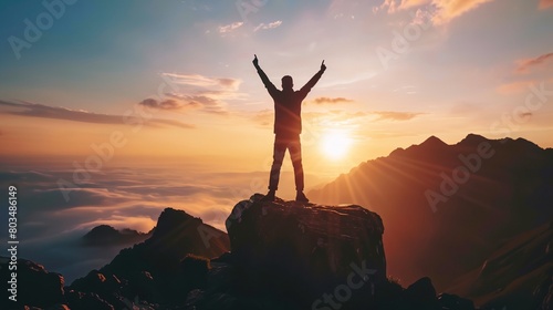 a man standing on top of a mountain with his arms up in the air