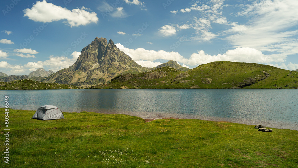 One tent near beautiful mountain lake in Pyrenees (Lacs d' Ayous), camping on popular hiking route, France