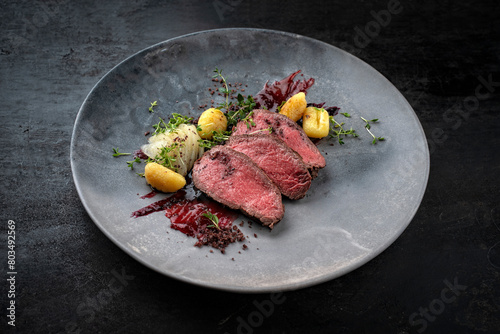 Bilde på lerret Traditional fried venison back filet with sliced pear, gnocchi and plum jam serv