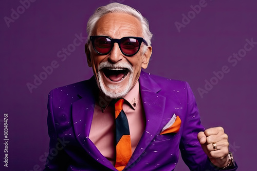 An older man dressed in a vibrant purple suit and an orange tie stands confidently