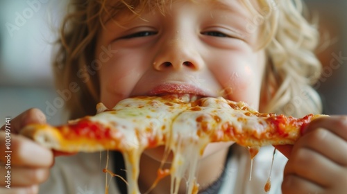 A child eagerly devouring a slice of pizza, with cheese stretching from the slice to their mouth in a deliciously gooey string. photo