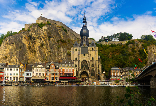 Picturesque view of Collegiate Church of Notre Dame on embankment of Meuse river and Citadel of Dinant on cliff  Belgium