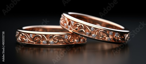 Two gold wedding rings with diamonds on a black background
