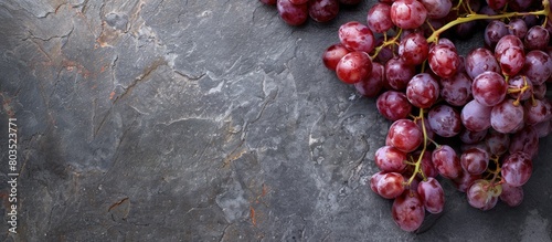 Ripe grapes on a stone background with copy space, showcasing the concept of organic food.