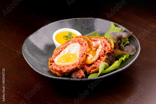 scotch egg Meat cutlet with boiled egg, pieces on a dark wooden background. Mini meat rolls. Scottish cutlet.
