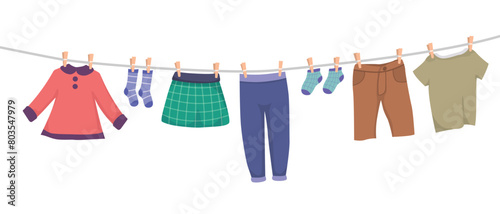 Set of children clothes hanging on rope clothesline