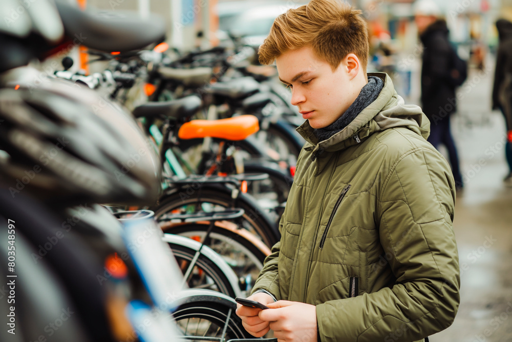Man looking at electric bikes in a cycle store. Urban lifestyle concept Man looking at electric bikes in a cycle store. Urban lifestyle concept