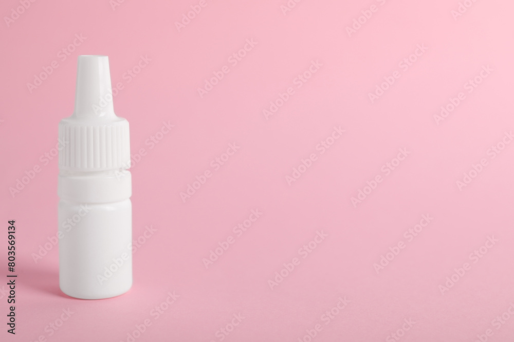 Bottle of medical drops on pink background, space for text Bottle of medical drops on pink background, space for text