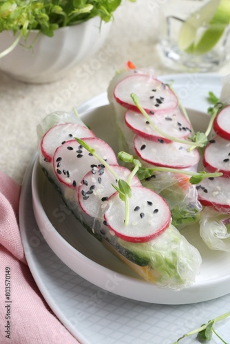 Delicious spring rolls wrapped in rice paper on table