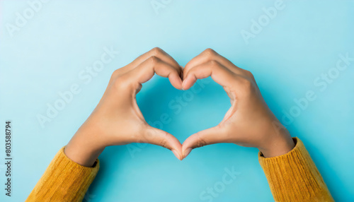 Top pov above overhead close up view photo of hands making shape of heart isolated over blue pastel color background 