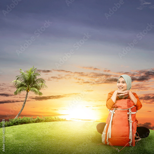Portrait of a woman in hijab with a backpack traveling to the meadow field