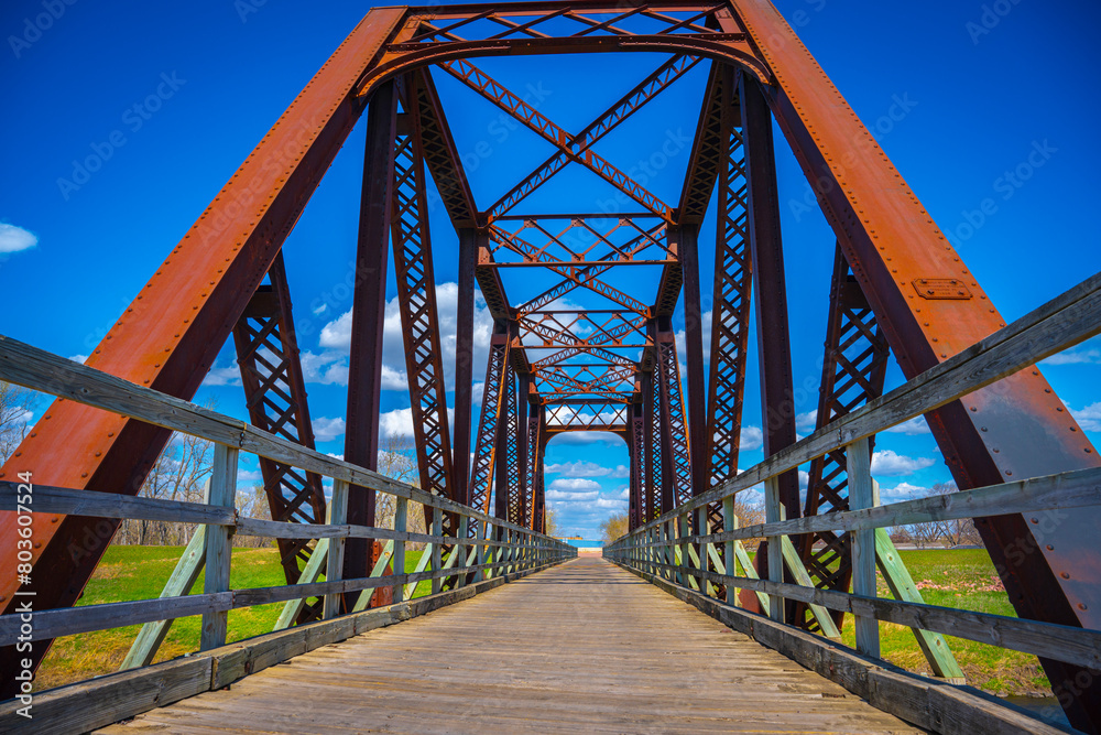 Old rustic railroad bridge over Big Sioux River walking trail near Sertoma Park in Sioux Falls, South Dakota,on a sunny spring afternoon Old rustic railroad bridge over Big Sioux River walking trail near Sertoma Park in Sioux Falls, South Dakota,on a sunny spring afternoon