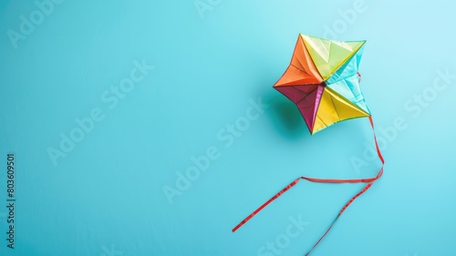 Colorful kite with tails against blue background photo