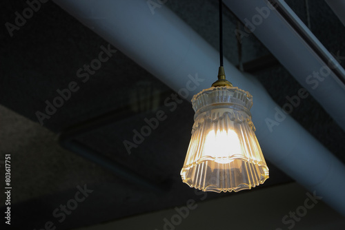 hanging light and concrete ceiling with pipe exposed