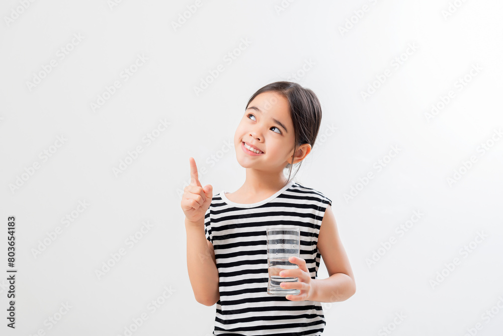 asian girl Standing and Smiling little with a holding an empty glass of water asian girl Standing and Smiling little with a holding an empty glass of water
