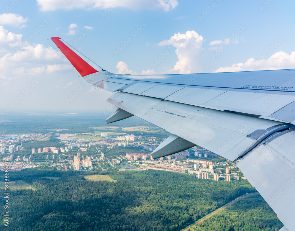 View from the airplane window during taking off on a clear summer morning