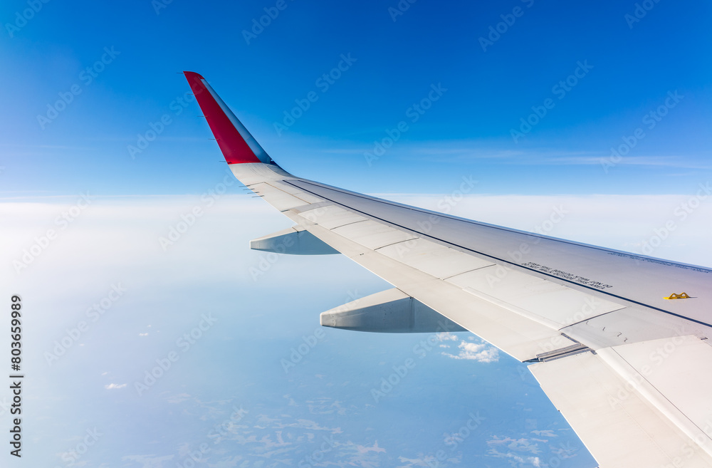 View from the airplane window at a beautiful cloudy sky and the airplane wing View from the airplane window at a beautiful cloudy sky and the airplane wing