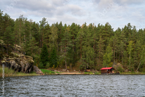 Wooden bathhouse and boat pier on the shore of Lake Ladoga near the village of Lumivaara on a sunny autumn morning, Ladoga Skerries, Lahdenpohya, Republic of Karelia, Russia photo