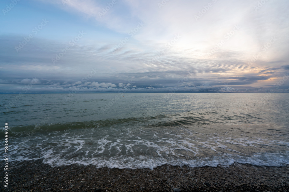 An incoming wave on the Black Sea coast against the sunset sky, Sochi, Krasnodar Territory, Russia An incoming wave on the Black Sea coast against the sunset sky, Sochi, Krasnodar Territory, Russia