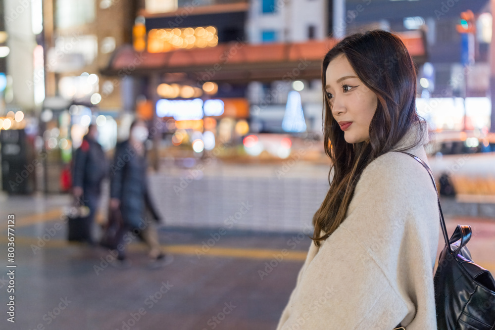 A Chinese woman in her 20s taking a walk at night in front of the station in Omiya Ward, Saitama City, Saitama Prefecture 埼玉県さいたま市大宮区の駅前を夜に散歩する２０代の中国人女性