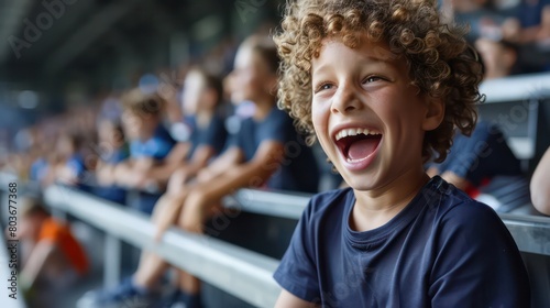 An excited young boy fan wearing a shirt cheering at the football stadium, cheering for their team to win the game.