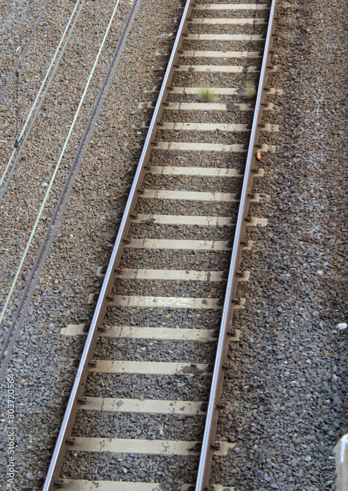 Close up view of railway tracks with parallel steel rails, wooden sleepers and a gravel bed Close up view of railway tracks with parallel steel rails, wooden sleepers and a gravel bed
