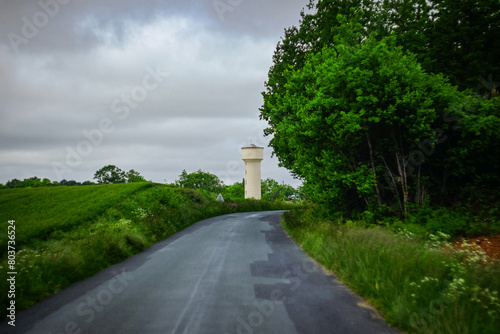 Curved country road with water tower in the distance  in Charente Maritime  France