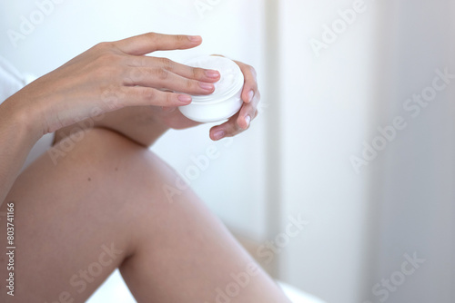 Close-up of beautiful hands holding a jar of skin care cream and moisturizer, healthy skin, skin care concept