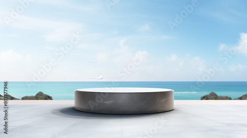 A large  round  grey stone sits on a beach near the ocean