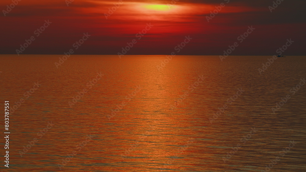 Beautiful Sunset Above Sea. Sun Sets Turning Red Tones And Reflects In Ocean.
