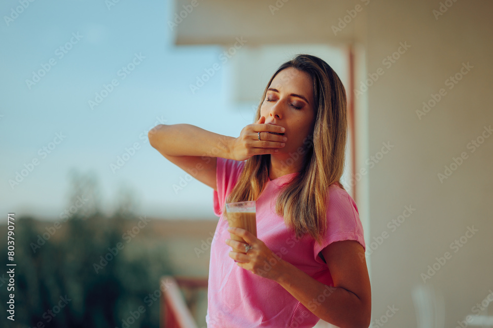 Woman Yawning Holding a Cold Coffee in a Glass. Tired girl having a frappe beverage early in the morning
Woman Yawning Holding a Cold Coffee in a Glass. Tired girl having a frappe beverage early in the morning