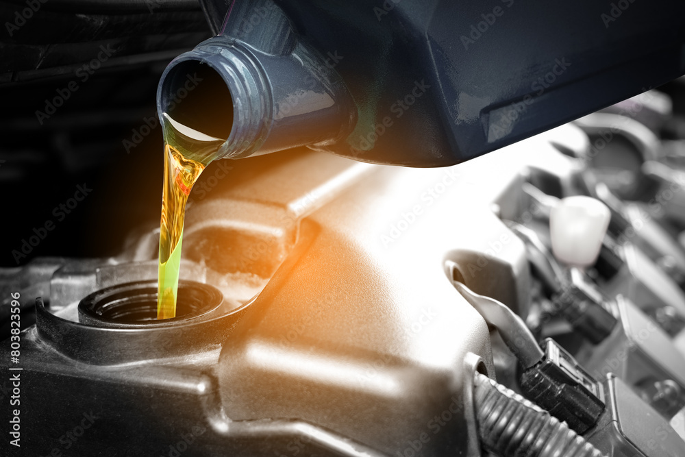 Refueling and pouring oil quality into the engine motor car Transmission and Maintenance Gear .Energy fuel concept. Refueling and pouring oil quality into the engine motor car Transmission and Maintenance Gear .Energy fuel concept.